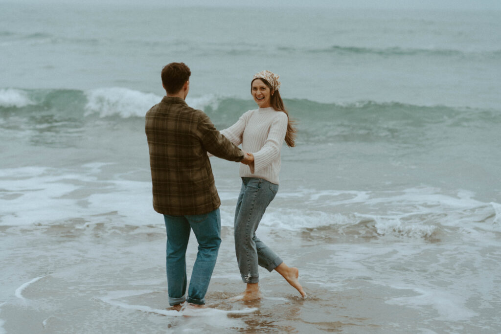 Couple playing in beach waves.
