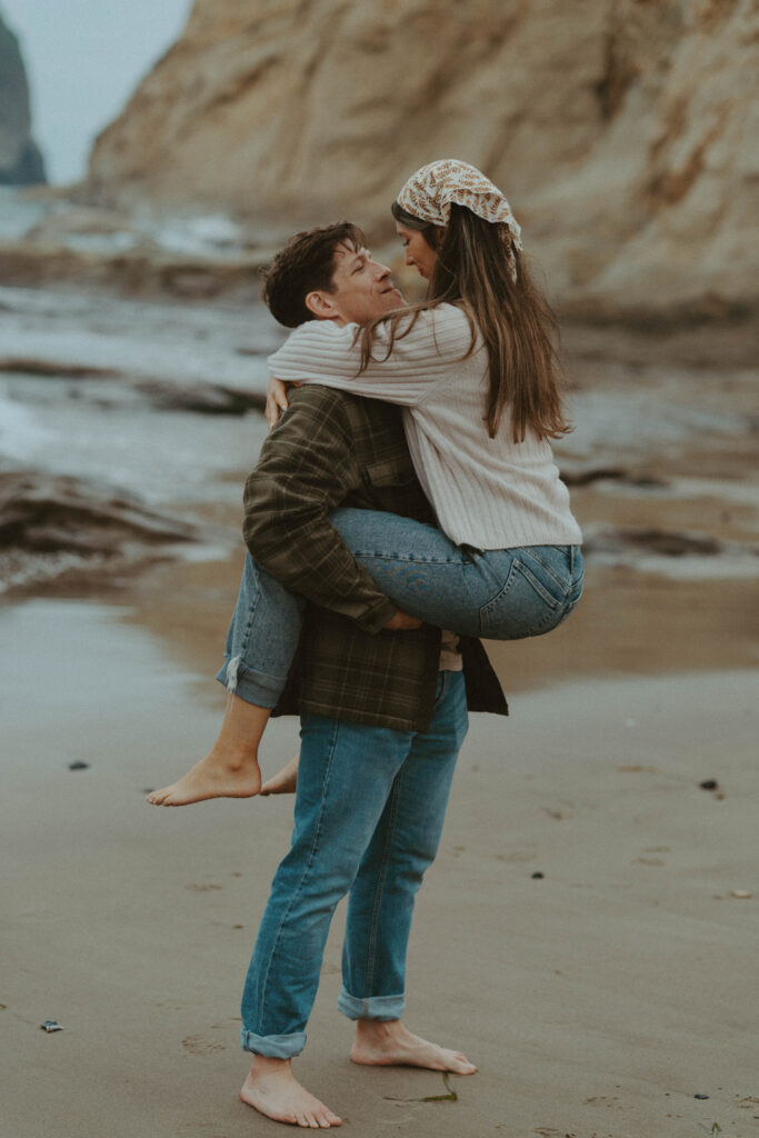 Boyfriend holding girlfriend on the beach.