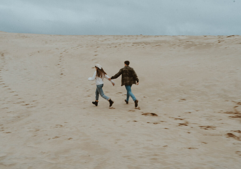 A couple running on a beach.